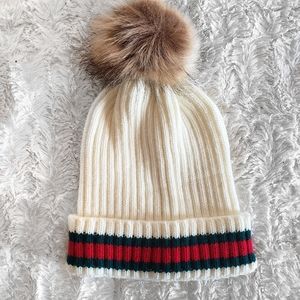 Off white beanie with a furry poof ball